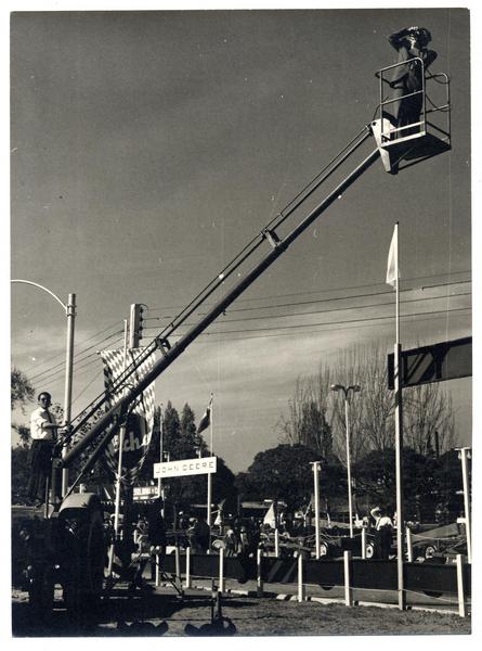 [Domingo Ulloa, suspendido en el aire sobre una escalera mecánica saca fotos de la Exposición Ganadera de la Quinta Normal].