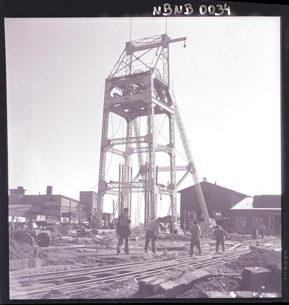 [mineros trabajando al exterior de la mina, y la estructura del ascensor]