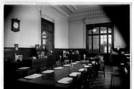[Biblioteca Nacional 1927. Salones interiores, con una mesa rectangular y varias personas]