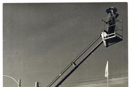 [Domingo Ulloa, suspendido en el aire sobre una escalera mecánica saca fotos de la Exposición Ganadera de la Quinta Normal].