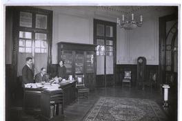 [Biblioteca Nacional. 1927. Salones interiores, oficina con dos hombres y una mujer]
