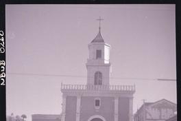 [Niña con un burrito que lleva carga, pasa frente a una capilla]