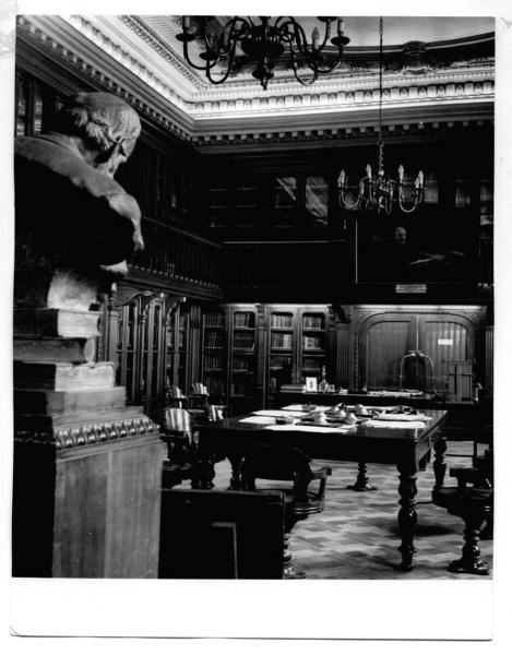 [Biblioteca Nacional. Sala de lectura de la Biblioteca Americana de Diego Barros Arana, se divisa estanterías, mesa rectangular y parte del busto de don Diego Barros Arana]