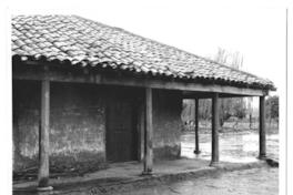 [Portal de una casa de adobe de campo, en un día de lluvia]