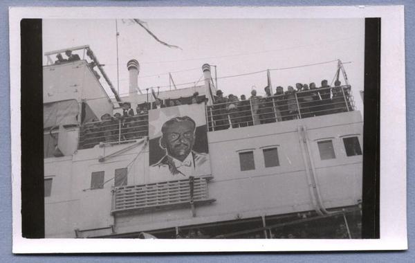 [Pasajeros refugiados republicanos españoles a bordo del Barco Winnipeg, anclado en Valparaíso. A un costado del barco una gran pintura del Presidente Pedro Aguirre Cerda]