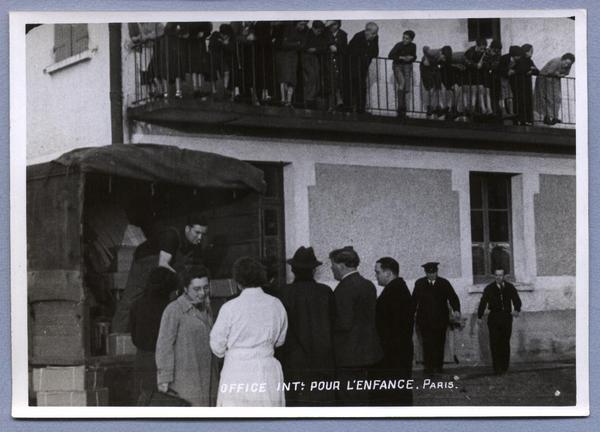 [Grupo de refugiados españoles recibiendo mercaderías, entregados desde un camión en el campo de refugiados de Dammarie, Francia]