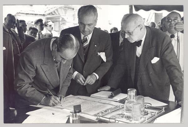 [Guillermo Feliú Cruz y dos personajes más, firmando un documento]