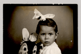 [Niña con una gran cinta blanca en el pelo y un conejo de peluche]