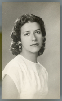 [Mujer joven de vestido blanco sin mangas, pelo rizado y aros largos]