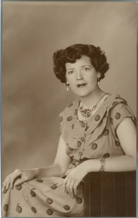[Mujer posando sentada y apoyada en un sillón de estudio]