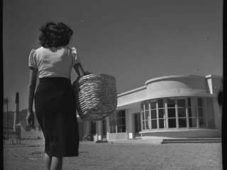 Mujer con canasto caminando hacia la pulper�a en el pueblo de Paipote