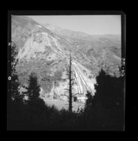 [Desarrollo de las tuberías desde la chimenea de equilibrio hasta la central y el entorno con gran vegetación en que predominan los cipreses]