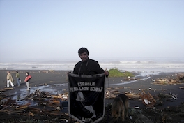 Profesor con pendón de la escuela "René León Echaíz", Iloca, febrero de 2010.