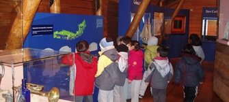 Niños y niñas jugando en el módulo interactivo sobre la Goleta Ancud.