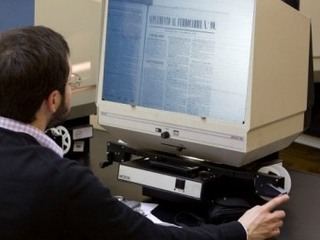 Alumno en práctica revisando microfilm.