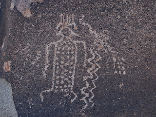 Petroglifo de figura antropomorfa con tocado y cuerpo decorado