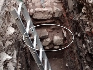 Excavación en Patio Los Naranjos de la Catedral Metropolitana. Abajo se ve el cimiento del muro posiblemente incaico, con su base de piedras rodadas (guijarros).