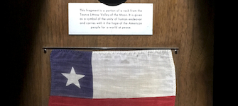 Roca lunar y bandera chilena en exhibición. La roca ha sido preservada al interior de una esfera de acrílico para la posteridad.