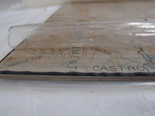 Proceso de remoción en forma mecánica del plástico autoadhesivo que envuelve por completo el plano. (Archivo CNCR, Arriagada, M. 2015)