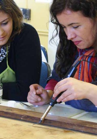 Pasante en investigación e intervención de pinturas de caballete junto a su tutora. Fotografía G. Reveco