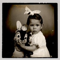 [Niña con una gran cinta blanca en el pelo y un conejo de peluche]