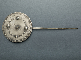 Tupu discoidal de plata o aleación base plata