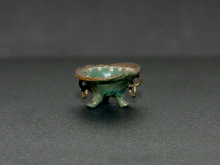 Brasero en miniatura de tres patas, con asas laterales y argollas colgantes