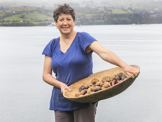 Marlene Álvarez sostiene fuente de madera con distintas variedades de papas nativas
