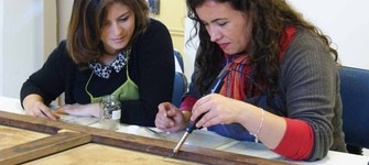 Pasante en investigación e intervención de pinturas de caballete junto a su tutora. Fotografía G. Reveco